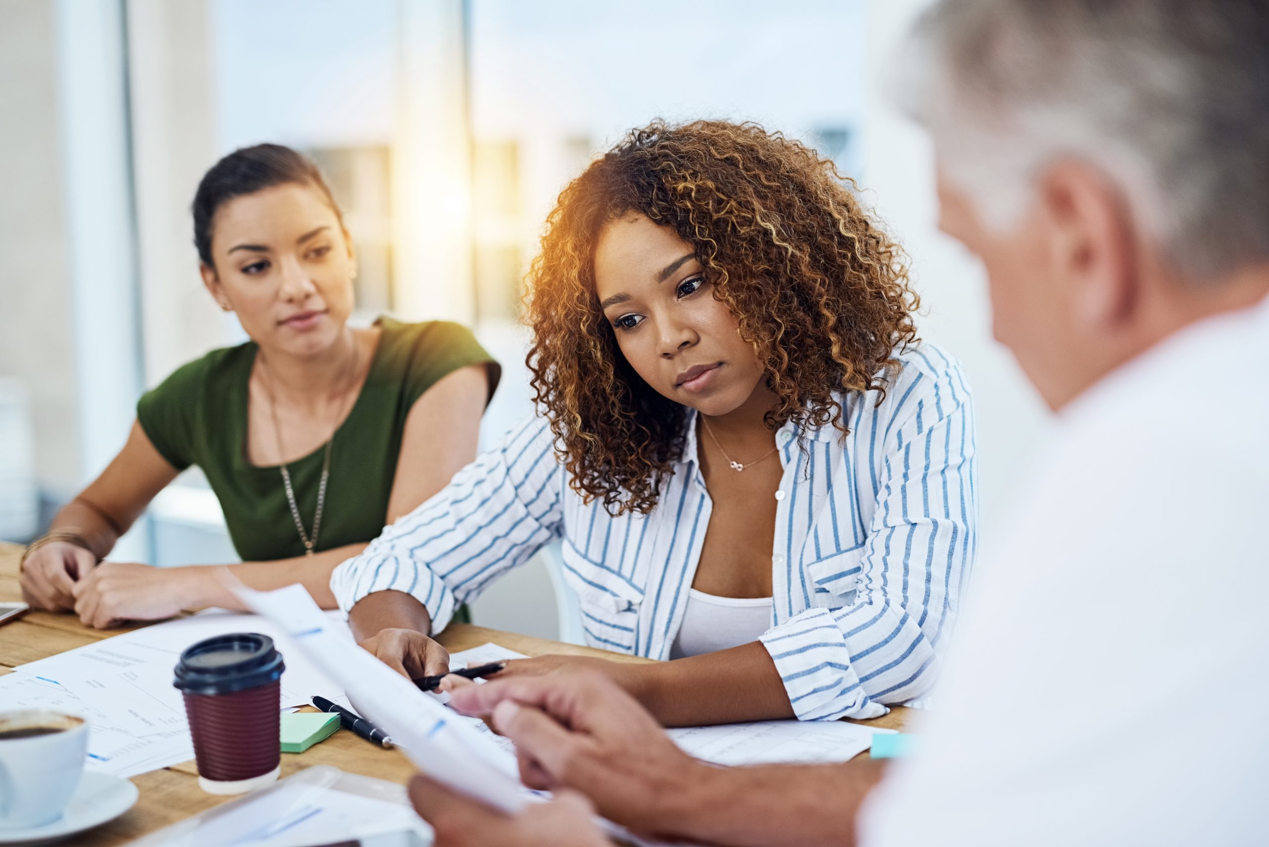 Employees sitting at a table looking at a document