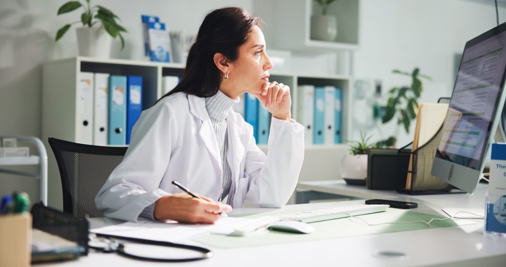 Computer, woman and doctor thinking with report in clinic for research, diagnosis or treatment. Tech, medical service and female healthcare worker with document for paperwork in hospital office.
