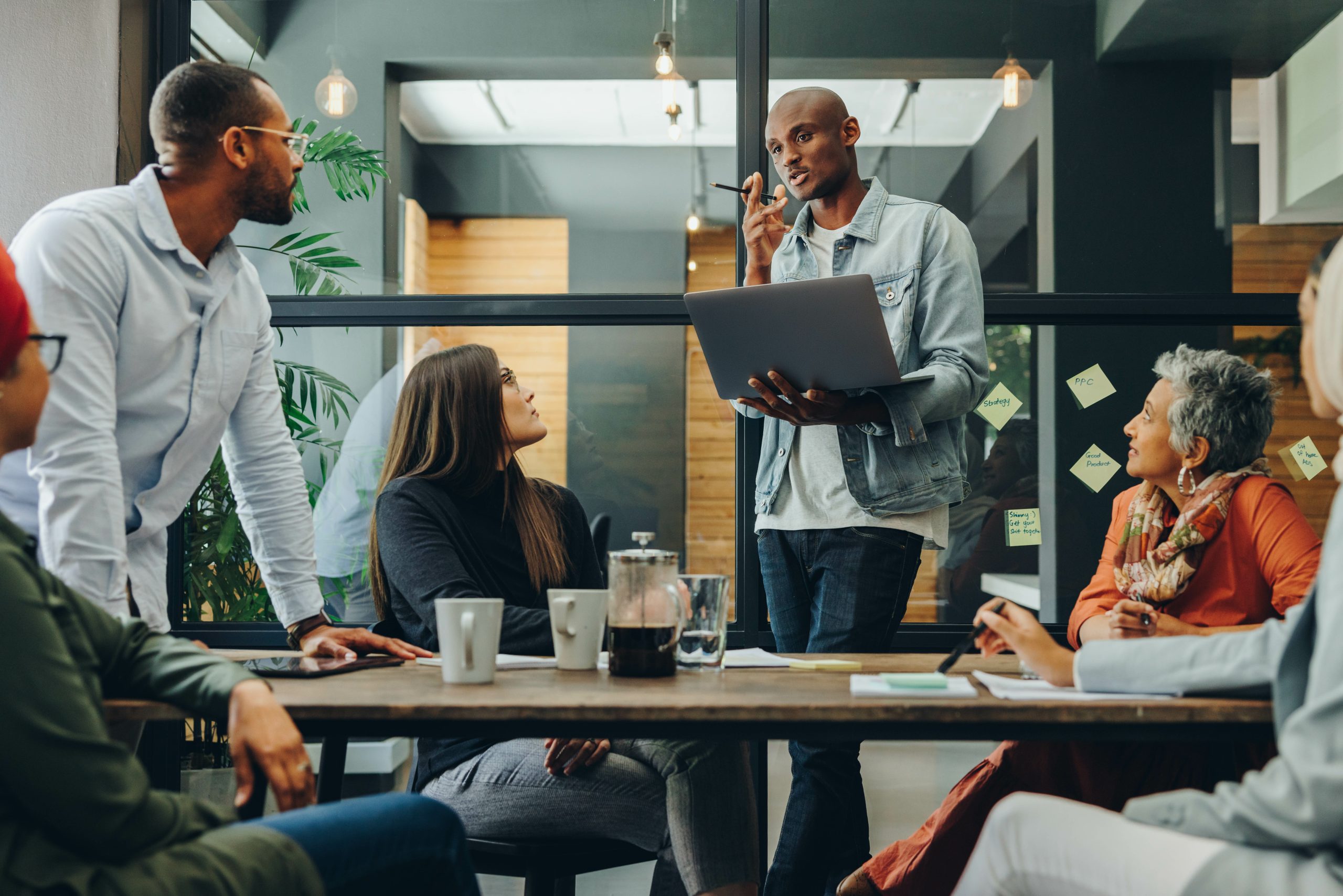 Diverse business professionals having a discussion during a meeting in a modern office. Team of multicultural businesspeople sharing creative ideas in an inclusive workplace. Leaders transformation
